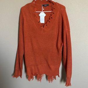 Orange sweater outlined in fringe